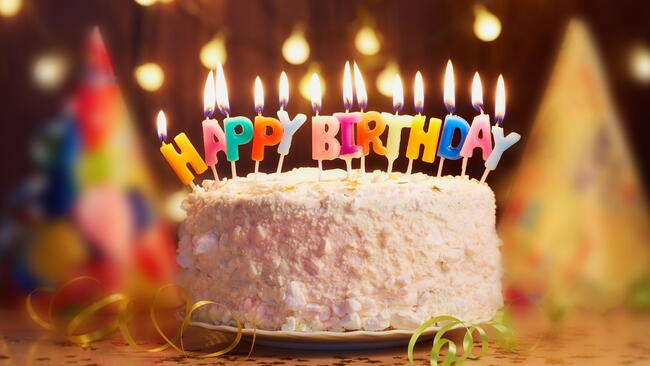 white birthday cake with happy birthday candles