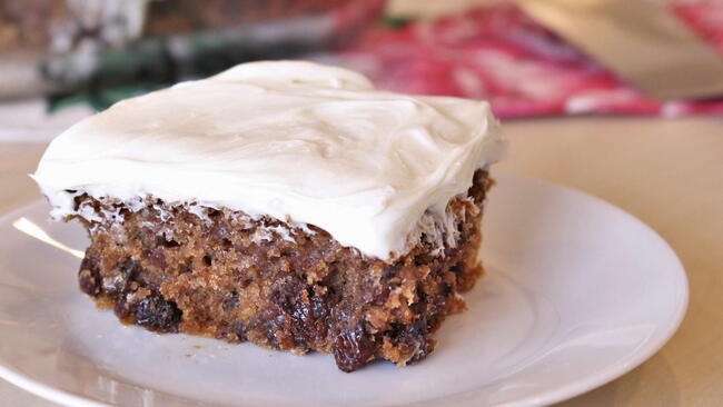 poor mans cake on a white plate. no eggs, butter or milk in this vegan cake recipe with raisins