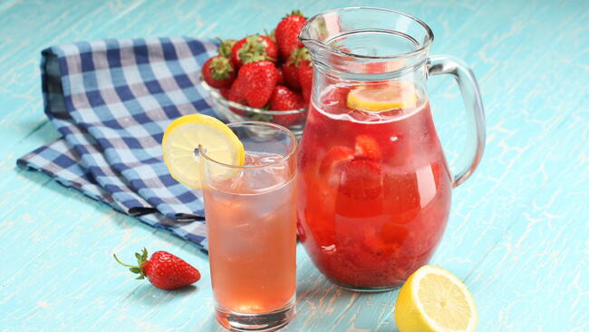 strawberry lemonade sweaty glass and the glass jar on the background of painted boards